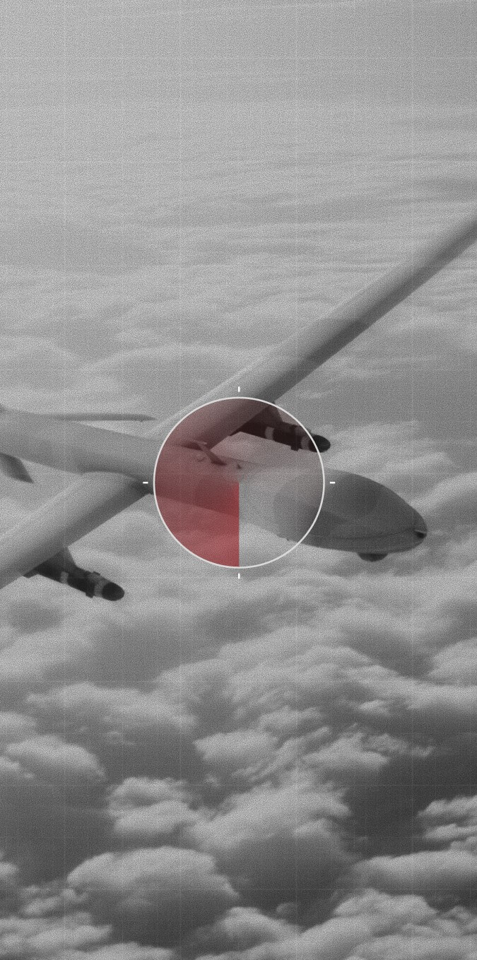 Aerial grayscale view of a drone flying above clouds with a targeting reticle and red highlight overlay on its fuselage.