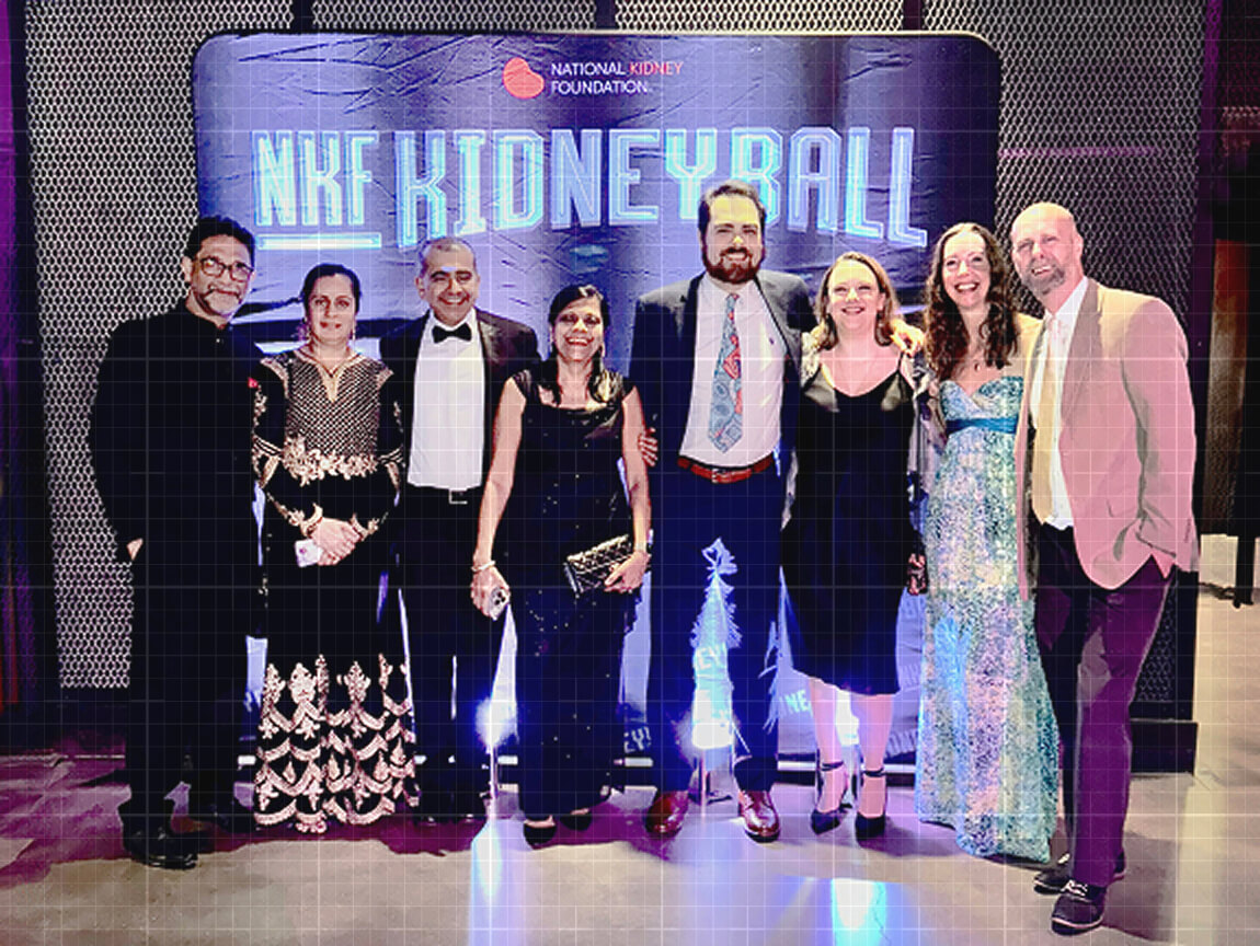 A group of eight formally dressed professionals posing together in front of the NKF Kidney Ball backdrop at a gala event.