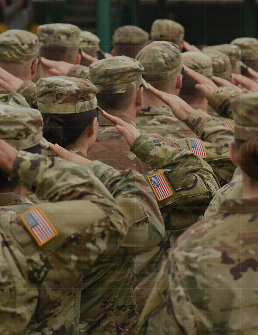 Credence-When-People-Thrive-Missions-Accelerate-Updated U.S. military soldiers in camouflage uniforms with American flag patches saluting in formation, viewed from behind.